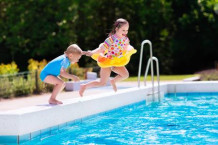 60370317-happy-little-girl-and-boy-holding-hands-jumping-into-outdoor-swimming-pool-in-a-tropical-resort-duri